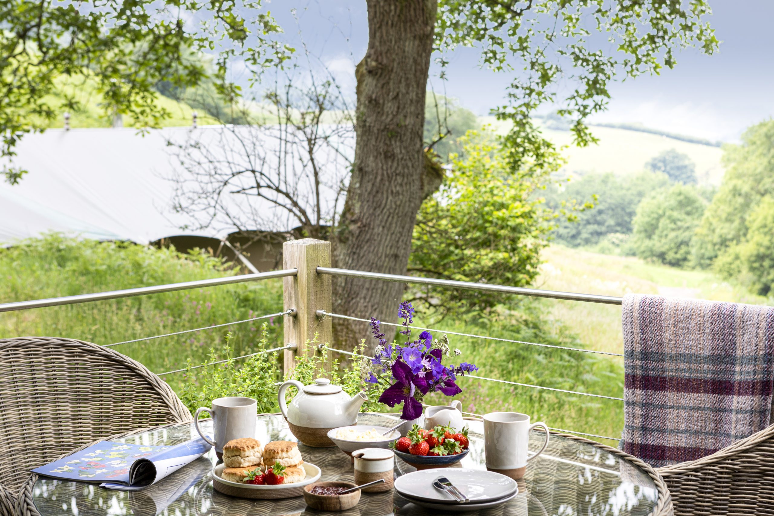 Afternoon tea set out on the deck of a luxury glamping lodge in North Devon